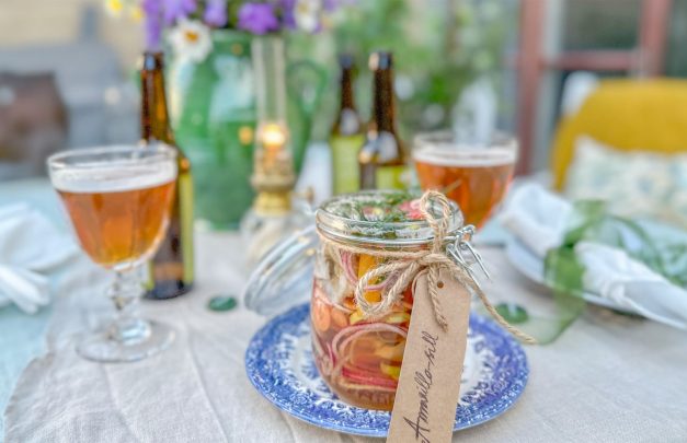 matbord dukat med sommarblommor, sillburk och öl från Oppigårds